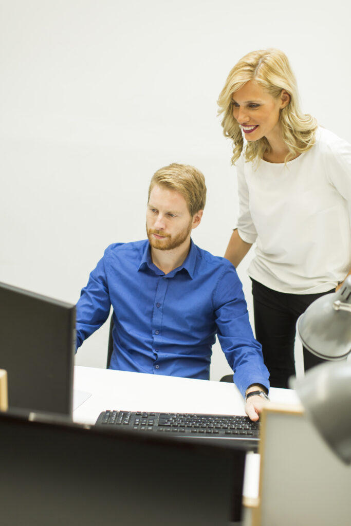 Young business couple using laptop in the office