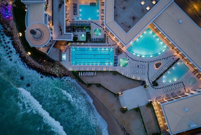 Aerial view of several pools in the spa center on a sea coast at night